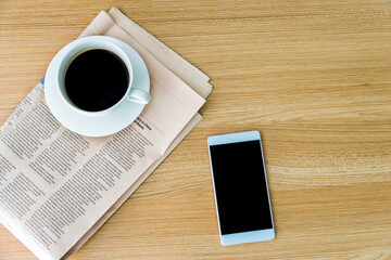 Fototapeta na wymiar Newspapers, coffee and smartphone on wooden table with top view