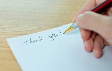Hand writing thank you on white paper