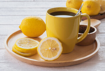Black coffee lemon in yellow ceramic cup.