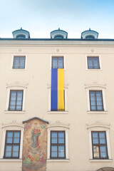 Fototapeta na wymiar Poland, Krakow, Main Market, March 2022, Ukrainian Flag on a Town House Facade