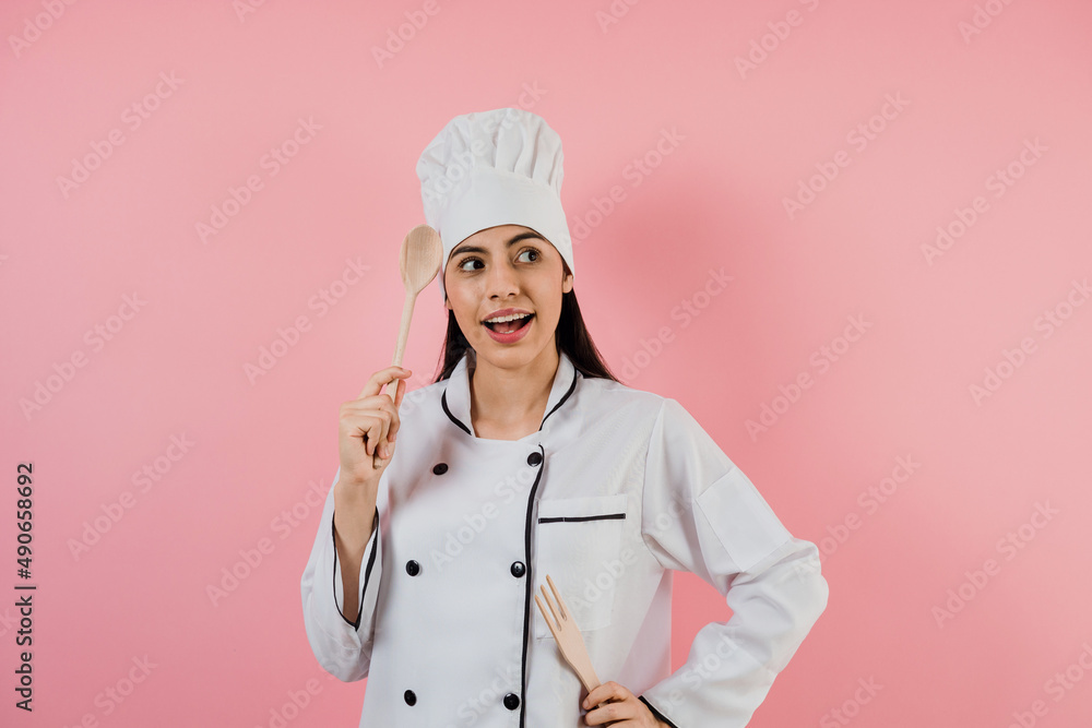 Wall mural Portrait of young mexican woman chef or baker on pink background in latin america	 - Wall murals