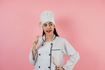 Portrait of young mexican woman chef or baker on pink background in latin america	