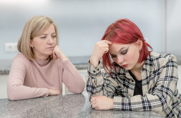 Family conflict. Unhappy mother and guilty daughter are offended at each other