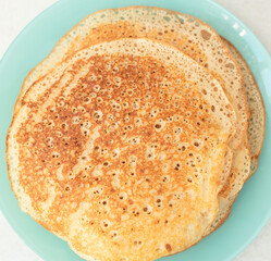 Homemade pancakes on blue plate. Maslenitsa, spring festival concept. Russian traditional food. Pancake week. Delicious breakfast. Flat lay style