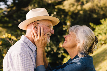 Cheerful senior couple smiling at each other and expressing their love