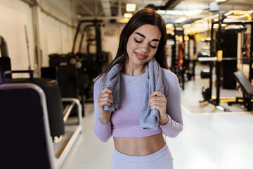 Cropped shot of a young girl resting after exercises in the gym, holding towel. Shot of a sporty young woman taking a break after her workout. Health and fitness concept.