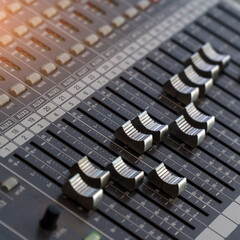 Faders and control buttons on the mixing console. Selective focus
