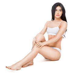 Fototapeta premium Fitness young woman with a beautiful body sitting on white background