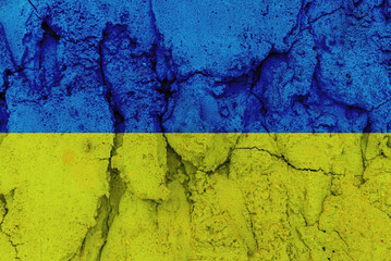Ukraine national flag.Cracked concrete wall gray cement surface background.cracked grey stone wall in winter.close-up.