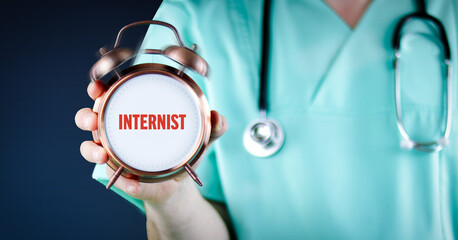 Internist (Arzt für innere Medizin). Arzt zeigt Wecker/Uhr mit Text. Hintergrund blau.