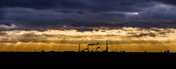 Rauchende Schornsteine im Sonnenuntergang