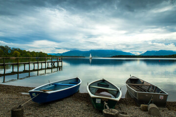 Fototapeta na wymiar Drei Ruderboote am Ufer eines Sees
