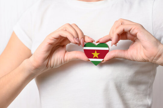 Flag of Suriname in the shape of a heart in the hands of a girl. Love Suriname. Respect for the people of Suriname