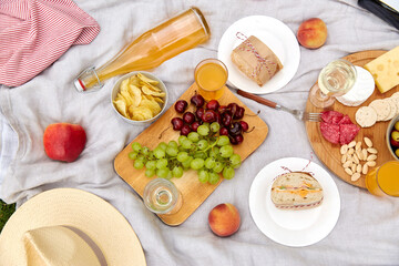 leisure and eating concept - close up of food and drinks on picnic blanket