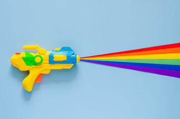 Water gun spray out with colorful cutting paper for Songkran festival celebration on blue color...