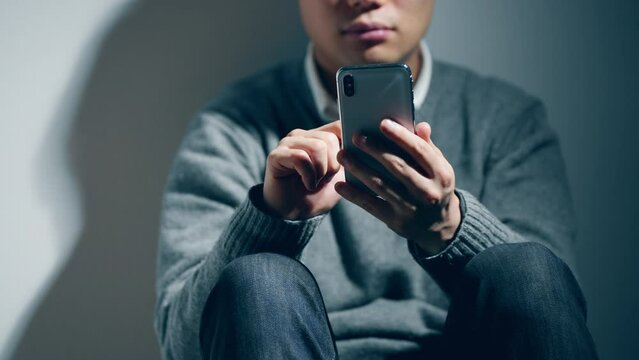精神障害を患っている男性がスマートフォンを使っている