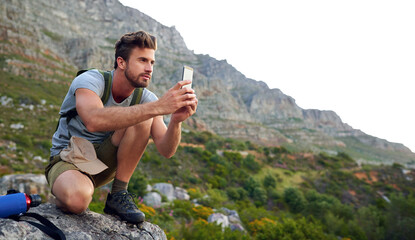 Ive gotta get some pics. Shot of a handsome young man snapping pics while hiking.
