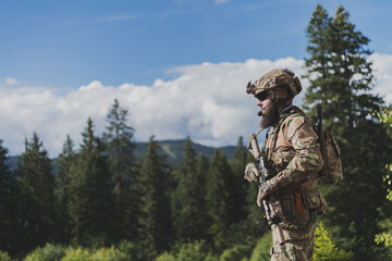 War concept. A bearded soldier in a special forces uniform fighting an enemy in a forest area....