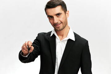 smiling portrait of a white man in a black suit pointing forward with his hand professional work white studio background, copy space
