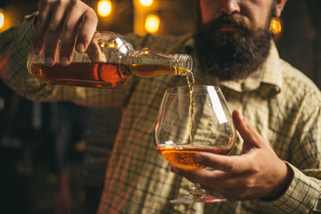 Man with glass brandy or cognac. Man holding a glass of whisky. Portrait of man with glass of whiskey isolated on black studio.