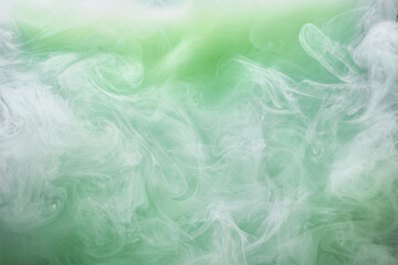 Fototapeta na wymiar Green smoke on white ink background, colorful fog, abstract swirling emerald ocean sea, acrylic paint pigment underwater