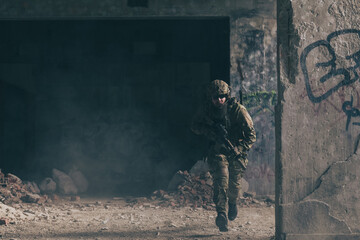 A bearded soldier in uniform of special forces in a dangerous military action in a dangerous enemy area. Selective focus 