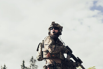 War concept. A bearded soldier in a special forces uniform fighting an enemy in a forest area....