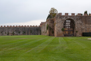 Fototapeta premium Fragment of the fortress wall enclosing the Leaning Tower of Pisa in Italy