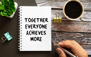 TEAM - together everyone achieves more - motivational text on a clipboard with a cup of coffee.