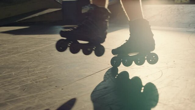 Young roller skater practicing stunt at skate park. Man legs in roller skates.