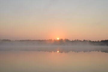 Sunrise on the lake. Forest lake in the early morning in summer. Foggy spring landscape