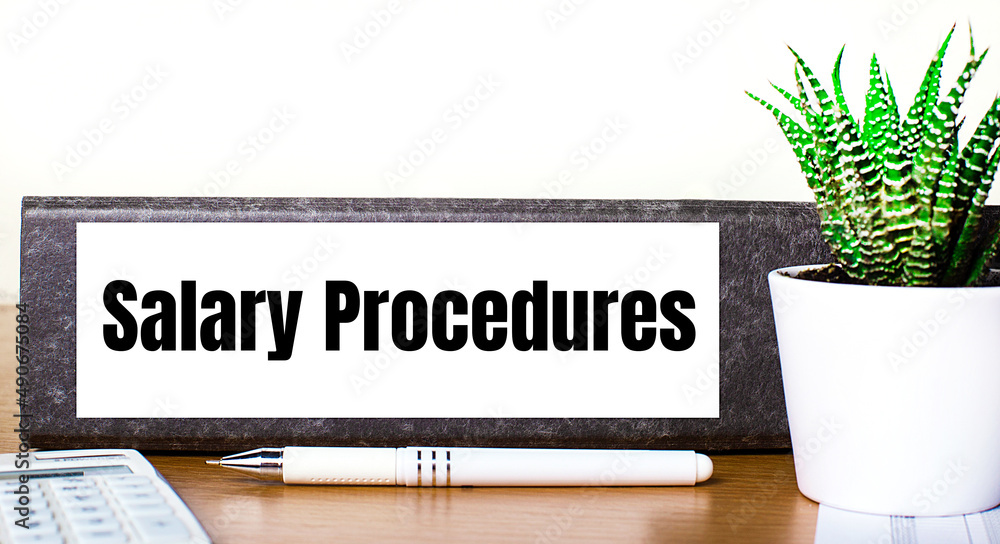 Poster on a wooden table is a folder for documents with the text salary procedures