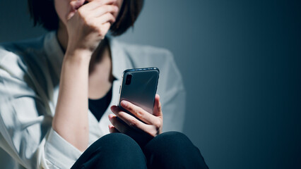 精神障害を患っている若い女性がスマートフォンを使っている