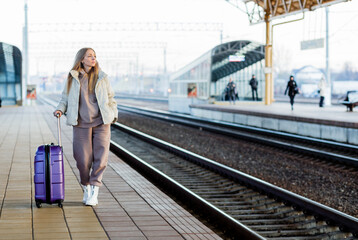 Obraz premium A young woman stands on the platform and waits for the train