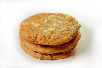 A stack of three home made chocolate chips sweet biscuits on a white background