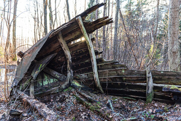 Fototapeta na wymiar Old abandoned wooden fishing boat in the forest. Boat cemetery.