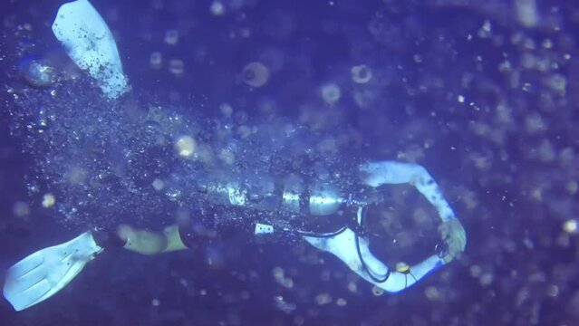 Underwater top view of diver who swim in sea full of oxygen bubbles. Maldives