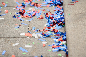 Multicolored confetti on the side of a city street, after a celebration event