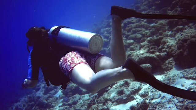 underwater close up view of woman who swim near coral reef. Maldives