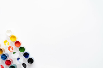 Flat composition a set of multi-colored paints in jars. Space for the text.