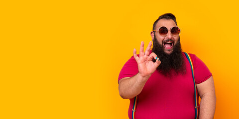Big happy bearded man wearing sunglasses and doing a perfect hand sign
