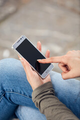 Young cute female using smartphone on the street.