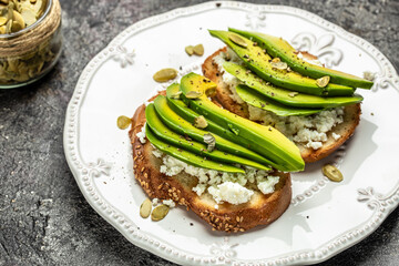 Toasts with avocado rye bread, sliced avocado, pumpkin seeds for breakfast or lunch. Vegetarian sandwiches. Healthy, clean eating concept. Vegan or gluten free diet. top view