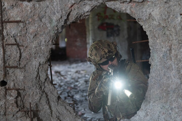A bearded soldier in uniform of special forces in a dangerous military action in a dangerous enemy area. Selective focus 