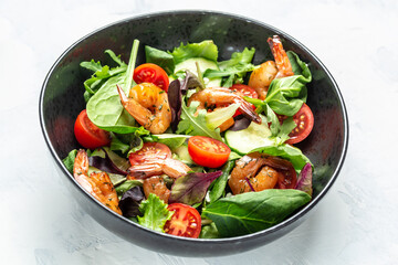 Seafood salad with smoked shrimps, cherry tomatoes, cucumber and mixed leaves. Healthy eating concept. Detox diet. Vegetarian lunch. Weight loss, top view