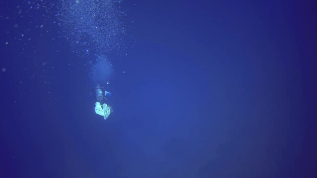 man swim with aqualung underwater. Maldives
