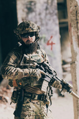A bearded soldier in uniform of special forces in a dangerous military action in a dangerous enemy area. Selective focus 