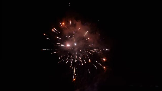 Small new year eve fireworks - glowing explosions on dark sky