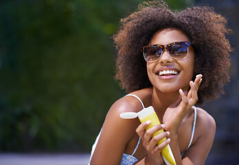 I cant believe Im finally on holiday. Shot of an attractive female holding sunscreen. - obrazy, fototapety, plakaty