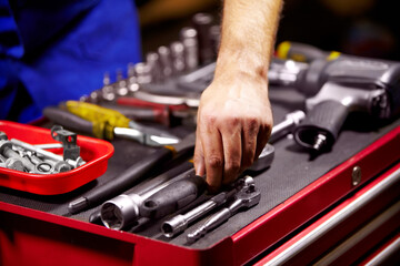 Finding the perfect tool. Cropped image of a mans hands grabbing a tool from his toolbox.